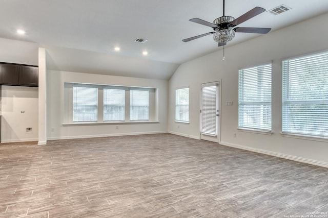 unfurnished living room featuring light hardwood / wood-style floors, vaulted ceiling, ceiling fan, and a healthy amount of sunlight