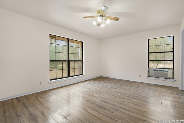 unfurnished room with ceiling fan, hardwood / wood-style floors, cooling unit, and a healthy amount of sunlight