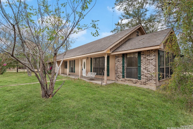 back of house featuring a lawn and a patio area