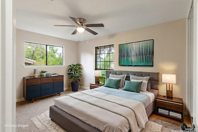 carpeted bedroom featuring ceiling fan and multiple windows