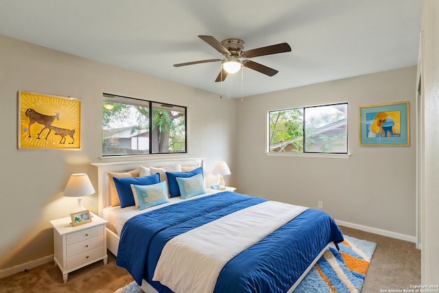 carpeted bedroom with ceiling fan and multiple windows