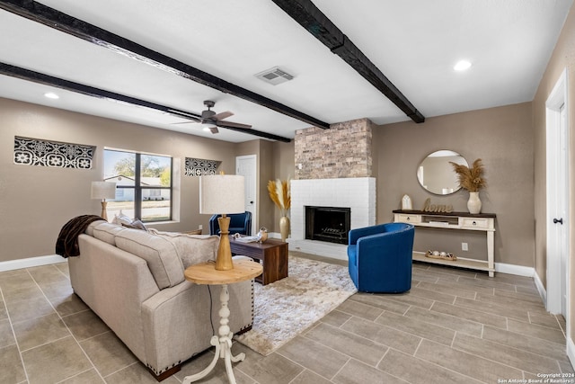 living room with ceiling fan, a fireplace, and beamed ceiling