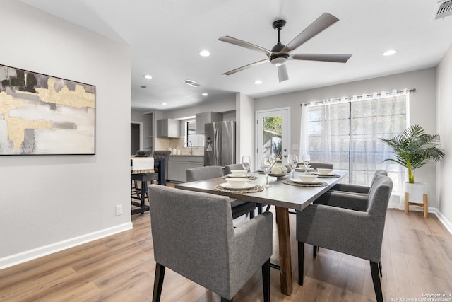 dining area with ceiling fan, sink, and light hardwood / wood-style floors