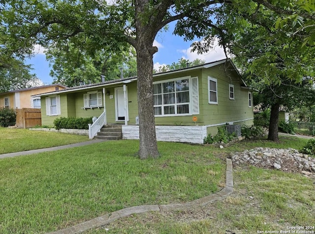 single story home with central AC unit and a front yard