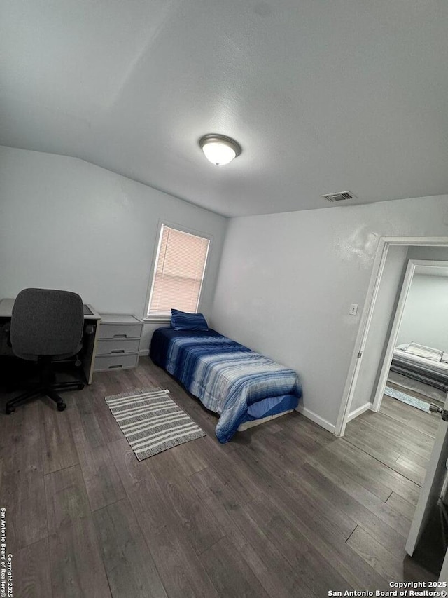 bedroom with dark hardwood / wood-style flooring