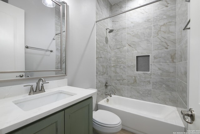 full bathroom featuring vanity, tiled shower / bath combo, and toilet