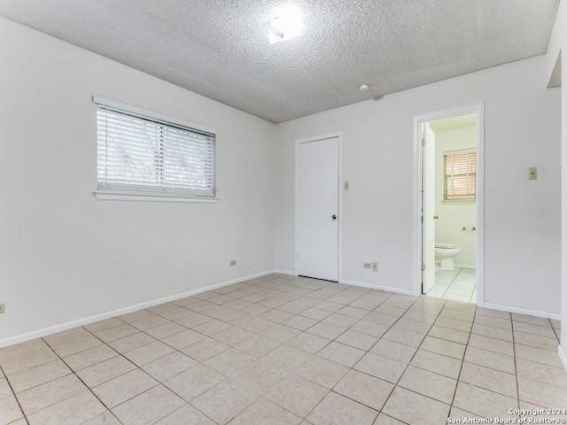 tiled spare room with a textured ceiling