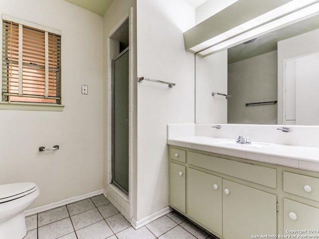 bathroom featuring tile patterned floors, vanity, toilet, and walk in shower