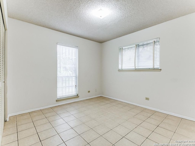 tiled spare room with a textured ceiling