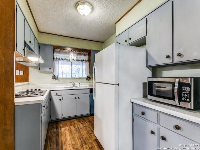 kitchen with sink, dark hardwood / wood-style flooring, a textured ceiling, and appliances with stainless steel finishes