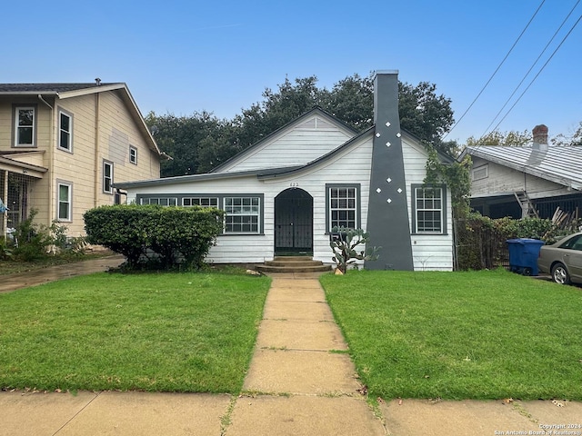 bungalow-style home with a front lawn