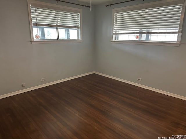 empty room with dark hardwood / wood-style flooring