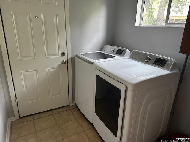 laundry room with washing machine and dryer and light tile patterned floors