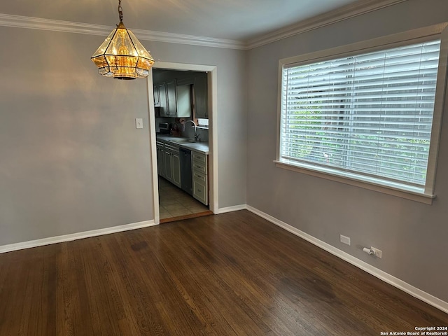 unfurnished dining area with crown molding, sink, dark hardwood / wood-style floors, and a notable chandelier