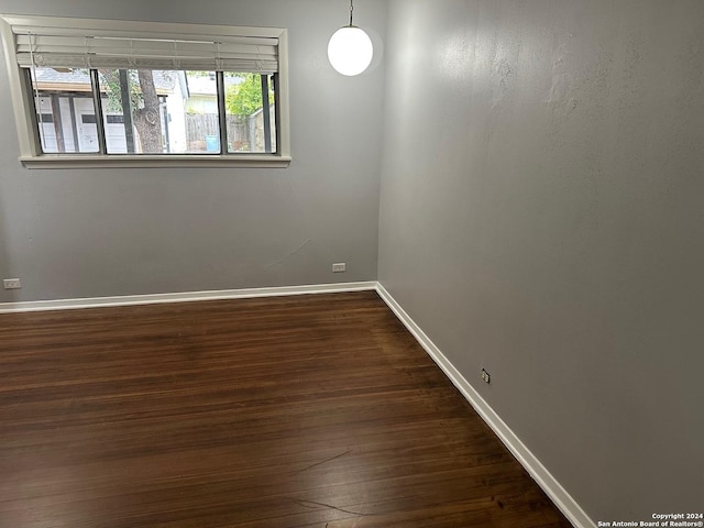 unfurnished room with dark wood-type flooring