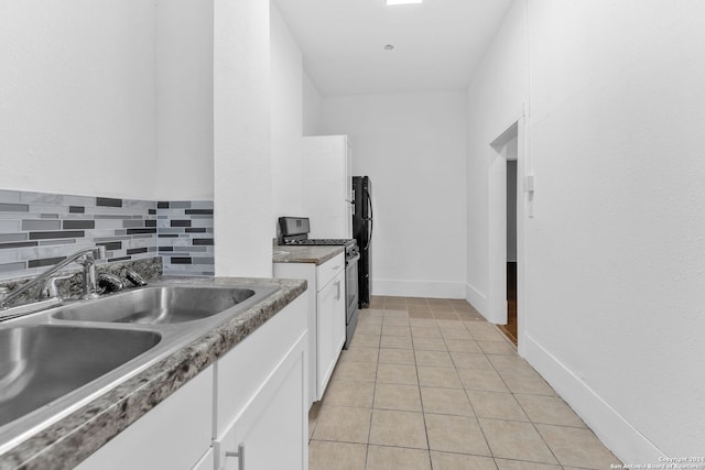 kitchen featuring white cabinetry, stainless steel gas stove, sink, tasteful backsplash, and light tile patterned flooring