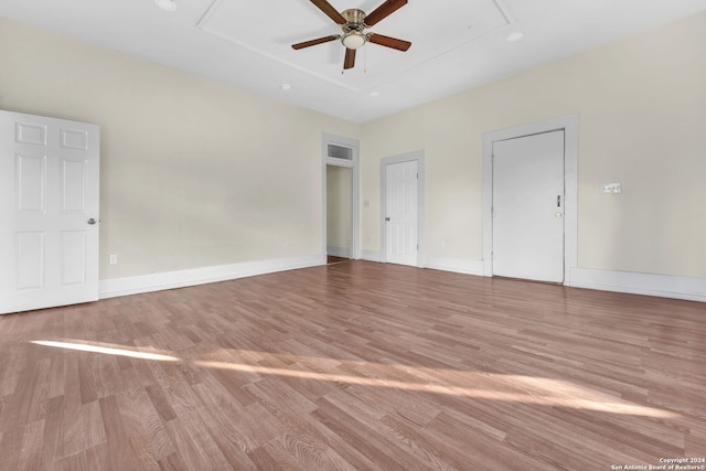 empty room with ceiling fan and light hardwood / wood-style flooring