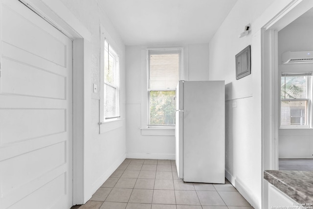 interior space featuring light tile patterned floors and a wall mounted air conditioner