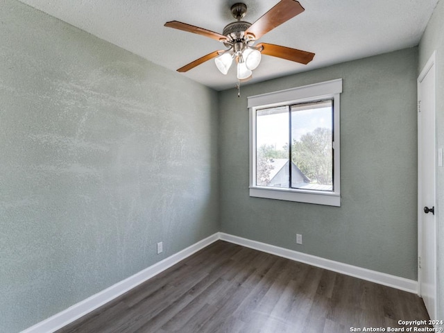 spare room with dark hardwood / wood-style floors and ceiling fan