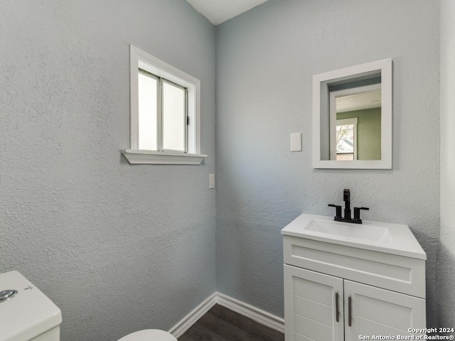 bathroom featuring a wealth of natural light, vanity, and toilet