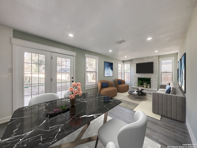 dining space with hardwood / wood-style flooring and a stone fireplace