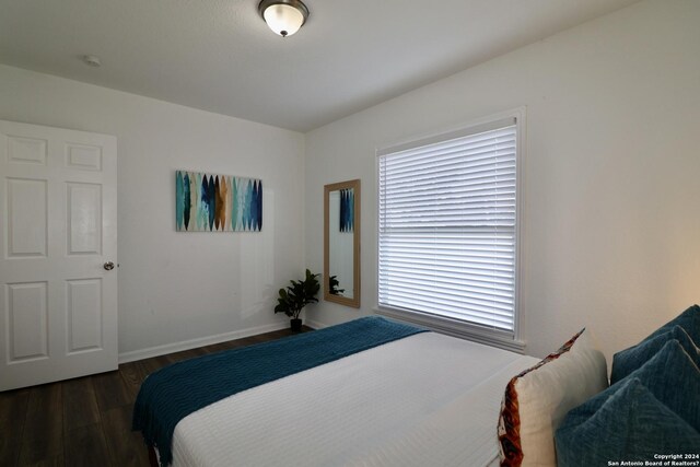 bedroom with dark hardwood / wood-style flooring