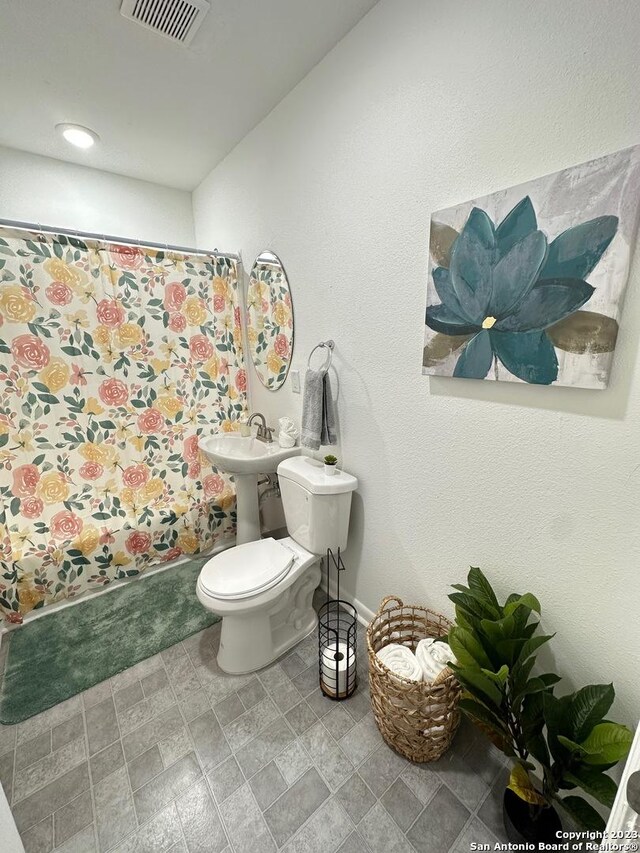 bathroom with toilet and curtained shower