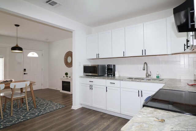 kitchen with white cabinets, decorative light fixtures, dark hardwood / wood-style floors, and sink