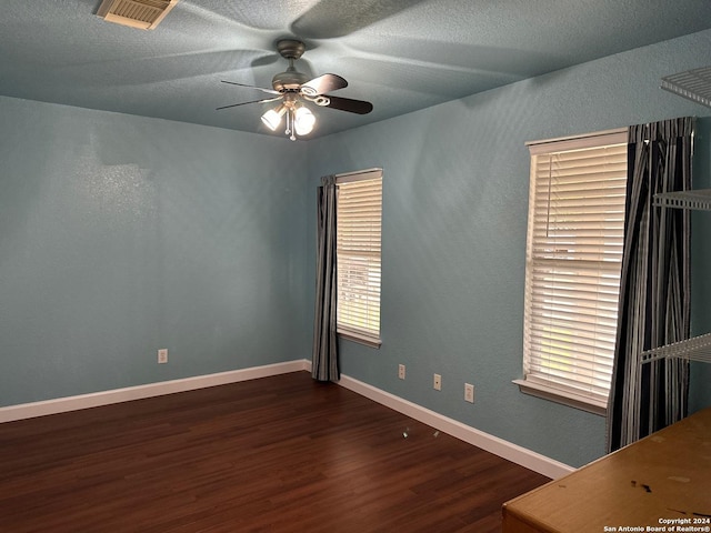 unfurnished room featuring a textured ceiling, dark hardwood / wood-style floors, and ceiling fan