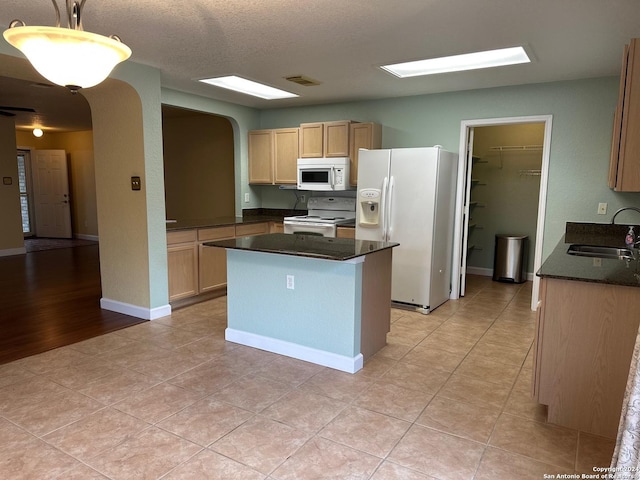 kitchen with light brown cabinetry, white appliances, sink, pendant lighting, and light hardwood / wood-style flooring