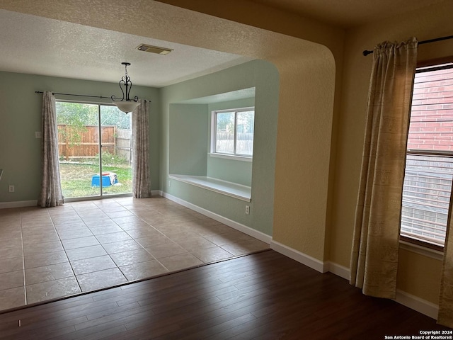 empty room featuring a textured ceiling and light wood-type flooring