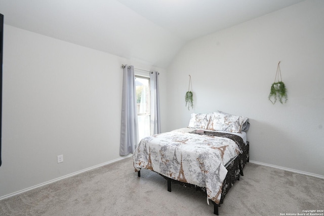 carpeted bedroom with lofted ceiling