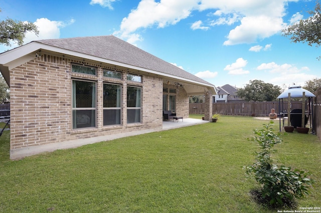 back of property with a yard and a patio area