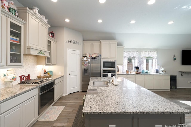 kitchen with sink, dark hardwood / wood-style flooring, stainless steel appliances, and an island with sink