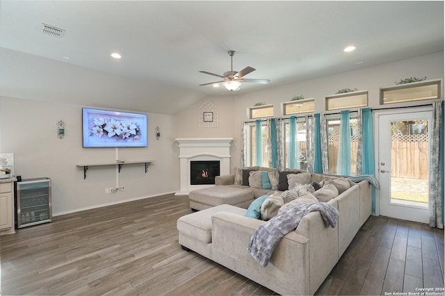 living room with ceiling fan, beverage cooler, lofted ceiling, and hardwood / wood-style flooring