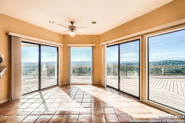 entryway featuring a wealth of natural light, ceiling fan, and a mountain view