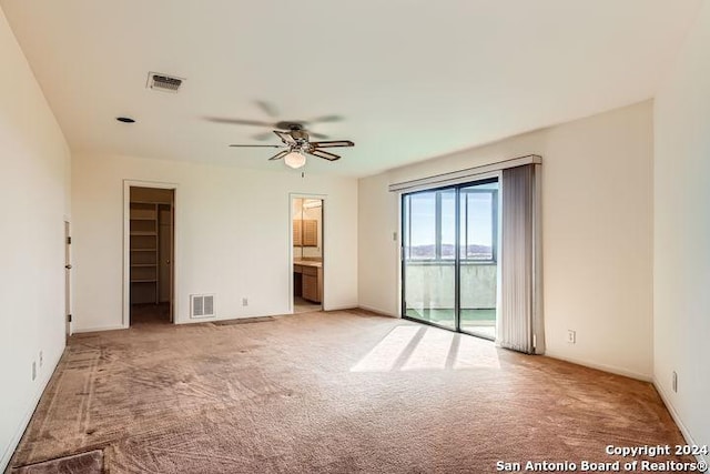 spare room with ceiling fan and light carpet