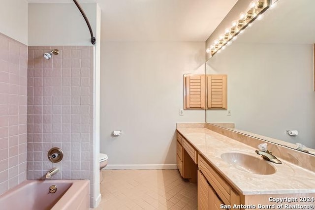 full bathroom featuring tile patterned flooring, tiled shower / bath combo, toilet, and vanity