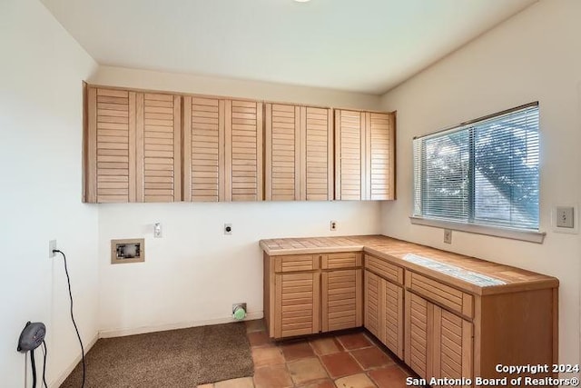 clothes washing area featuring hookup for an electric dryer, cabinets, and washer hookup