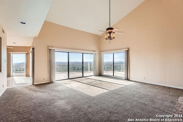 empty room featuring carpet, high vaulted ceiling, and a wealth of natural light