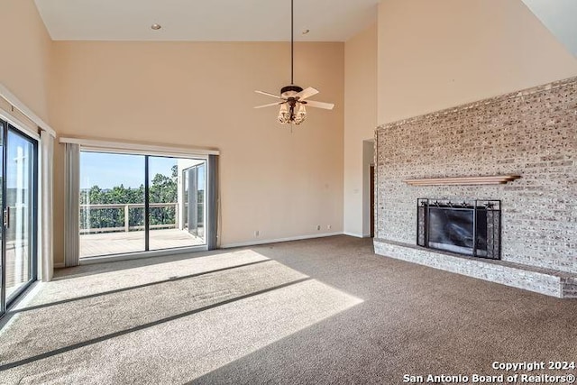 unfurnished living room featuring a fireplace, carpet flooring, high vaulted ceiling, and plenty of natural light