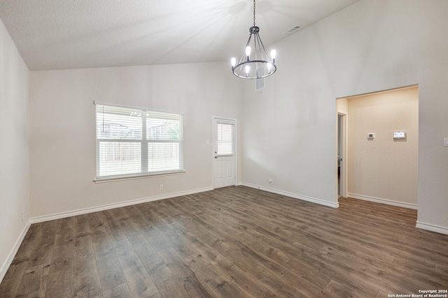 empty room with dark hardwood / wood-style floors, high vaulted ceiling, and a chandelier