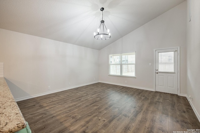 unfurnished dining area with dark hardwood / wood-style flooring, high vaulted ceiling, and a notable chandelier