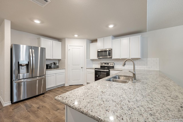 kitchen with white cabinetry, sink, dark wood-type flooring, tasteful backsplash, and appliances with stainless steel finishes