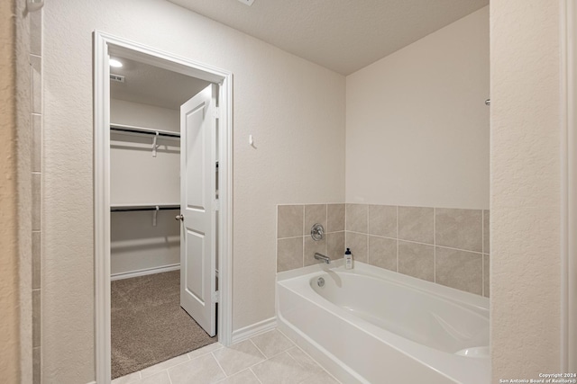 bathroom featuring tile patterned flooring, a textured ceiling, and a bathing tub