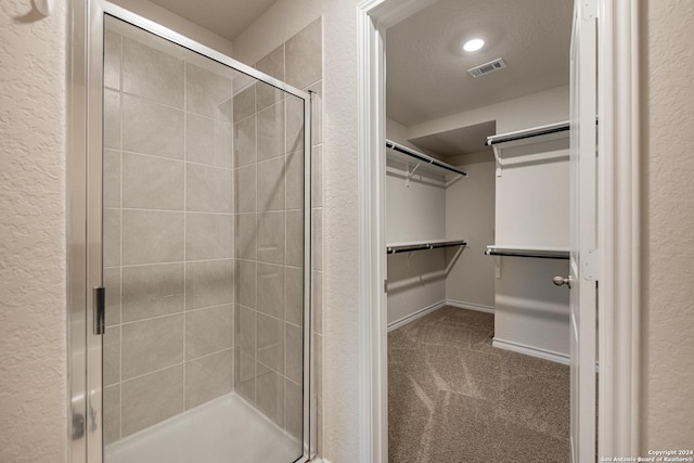 bathroom featuring a textured ceiling and walk in shower