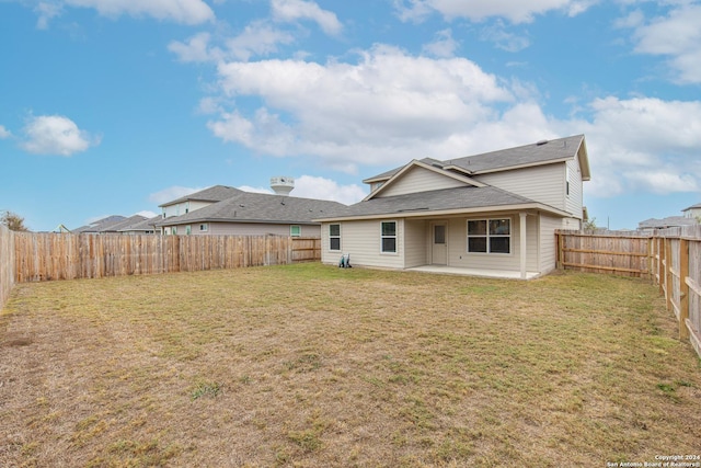 rear view of property with a lawn and a patio