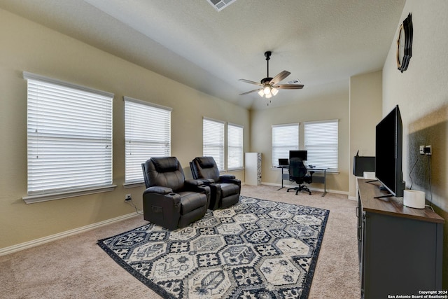 carpeted living room featuring ceiling fan and a textured ceiling