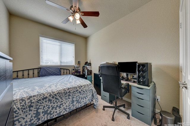 bedroom with a textured ceiling, light colored carpet, and ceiling fan