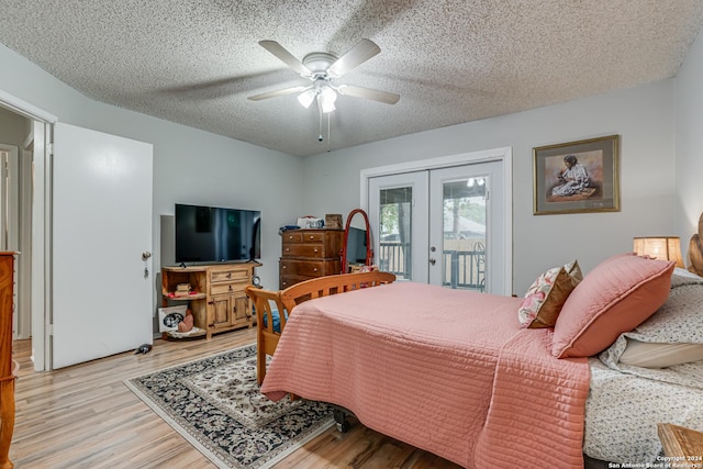 bedroom featuring french doors, a textured ceiling, access to outside, ceiling fan, and light hardwood / wood-style floors